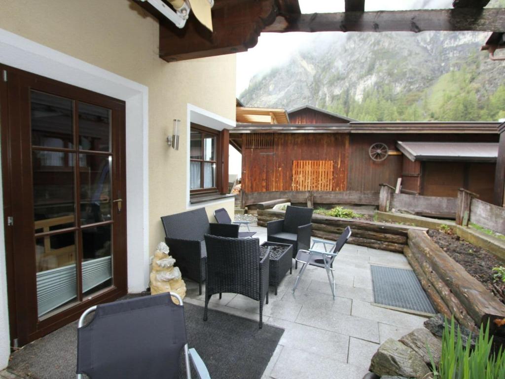 eine Terrasse mit Stühlen und einem Tisch auf der Terrasse in der Unterkunft Cozy Apartment in L ngenfeld With Sauna in Huben