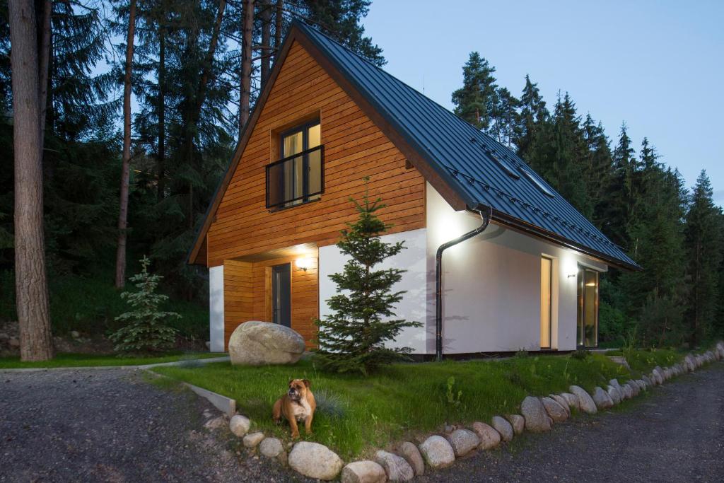 a dog standing in front of a small house at Chata Večernica in Liptovský Mikuláš