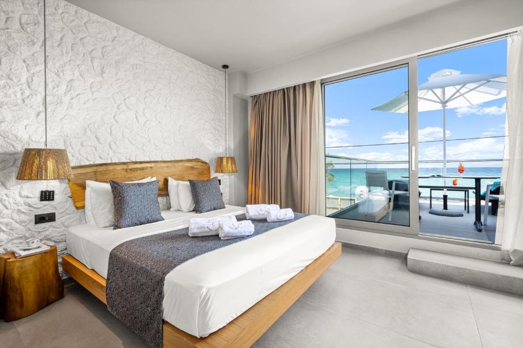 a bedroom with a large bed and a large window at Emily's Luxury Suites in Pefkochori