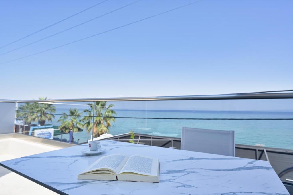 a table with two books and a cup of coffee on it at Emily's Luxury Suites in Pefkochori