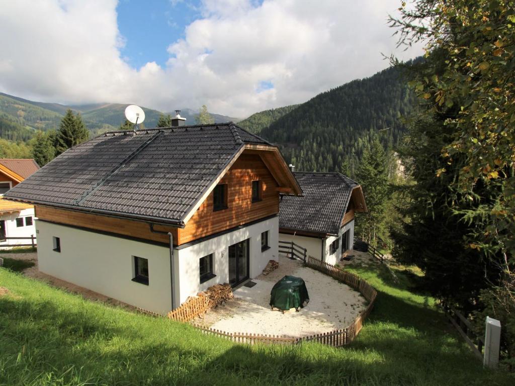 ein kleines Haus auf einem Feld mit Bergen im Hintergrund in der Unterkunft Chalet in Bad Kleinkirchheim with sauna in Bad Kleinkirchheim