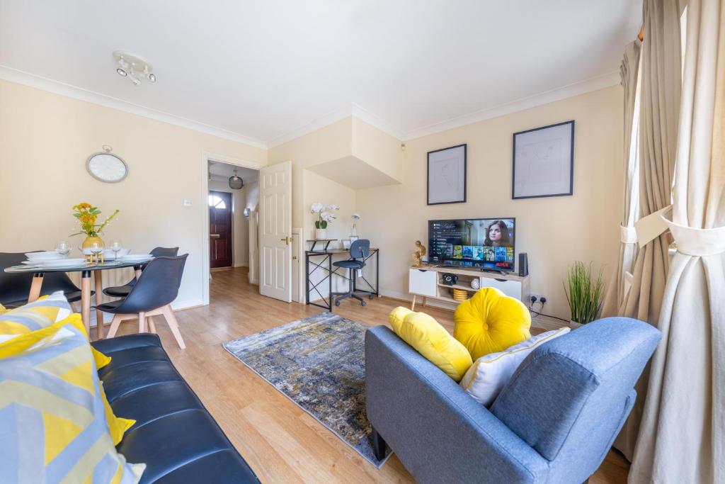 un salon avec un canapé bleu et une télévision dans l'établissement Pierocks Wickets Luxury Entire house, Free Parking and WI-FI in Maidenhead, à Maidenhead