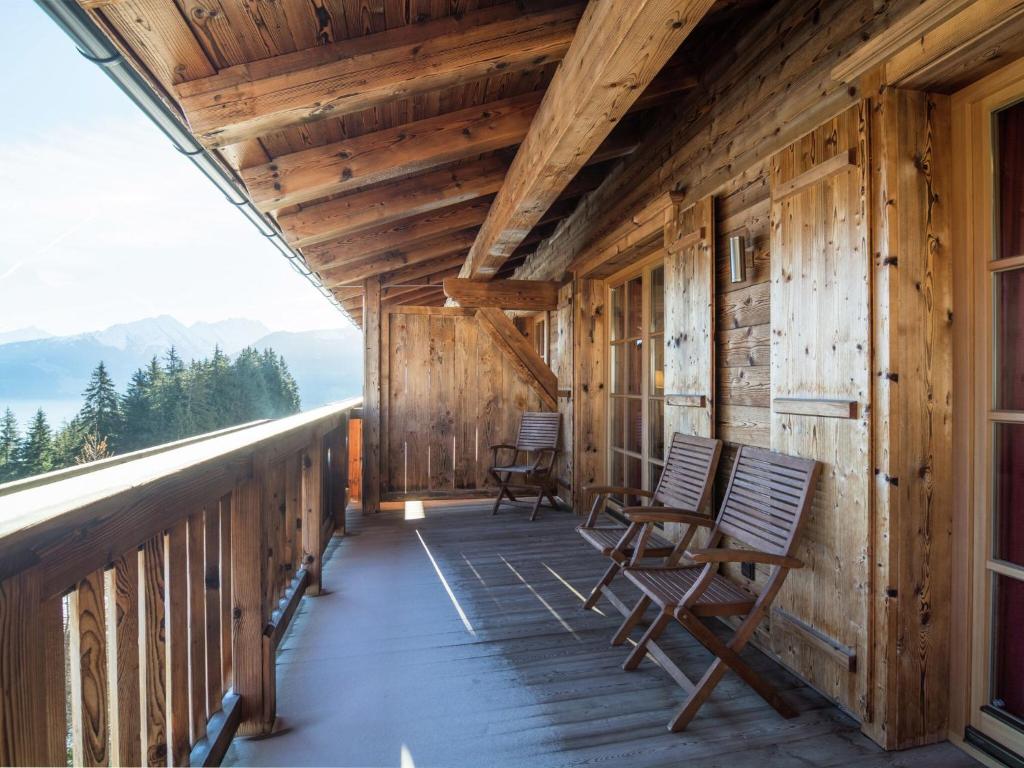 Elegant chalet with sauna in Mittersill Salzburg في هولرسباخ ام بنزغ: شرفة كابينة خشبية مع كراسي هزاز