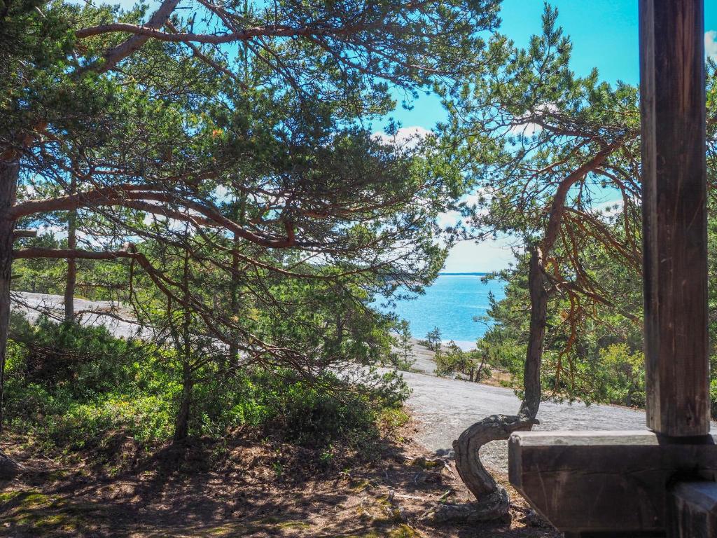 a view of the ocean from a beach with a tree at Spauna in Kustavi