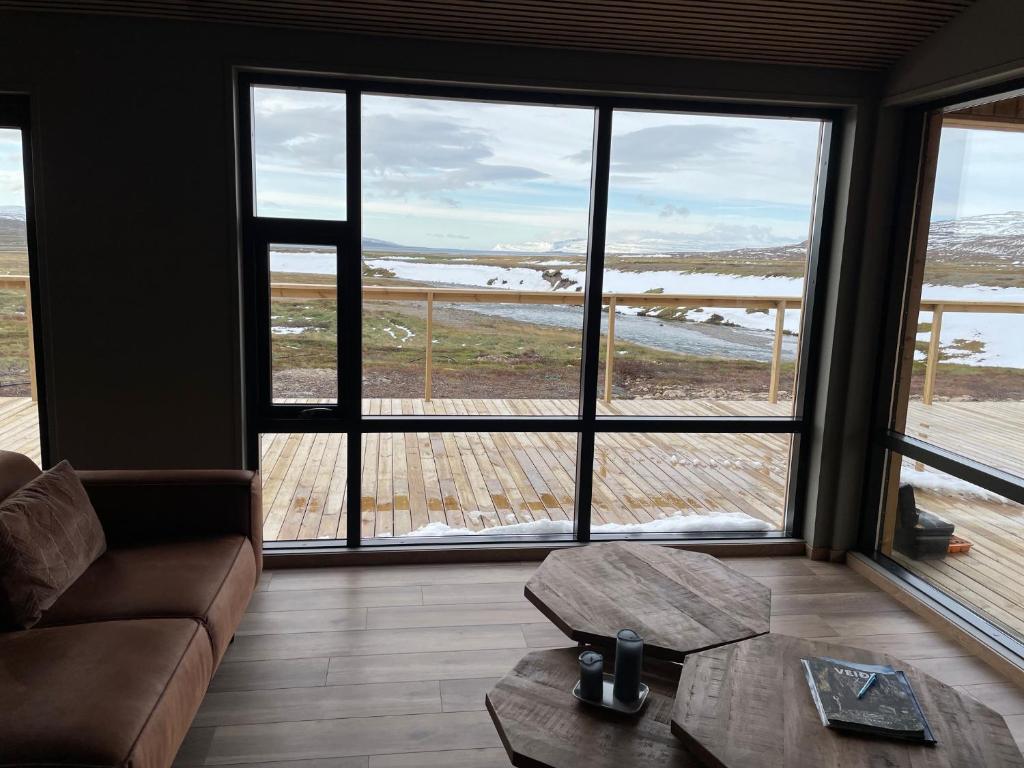 a living room with a couch and a table and windows at Dalamynni in Hólmavík