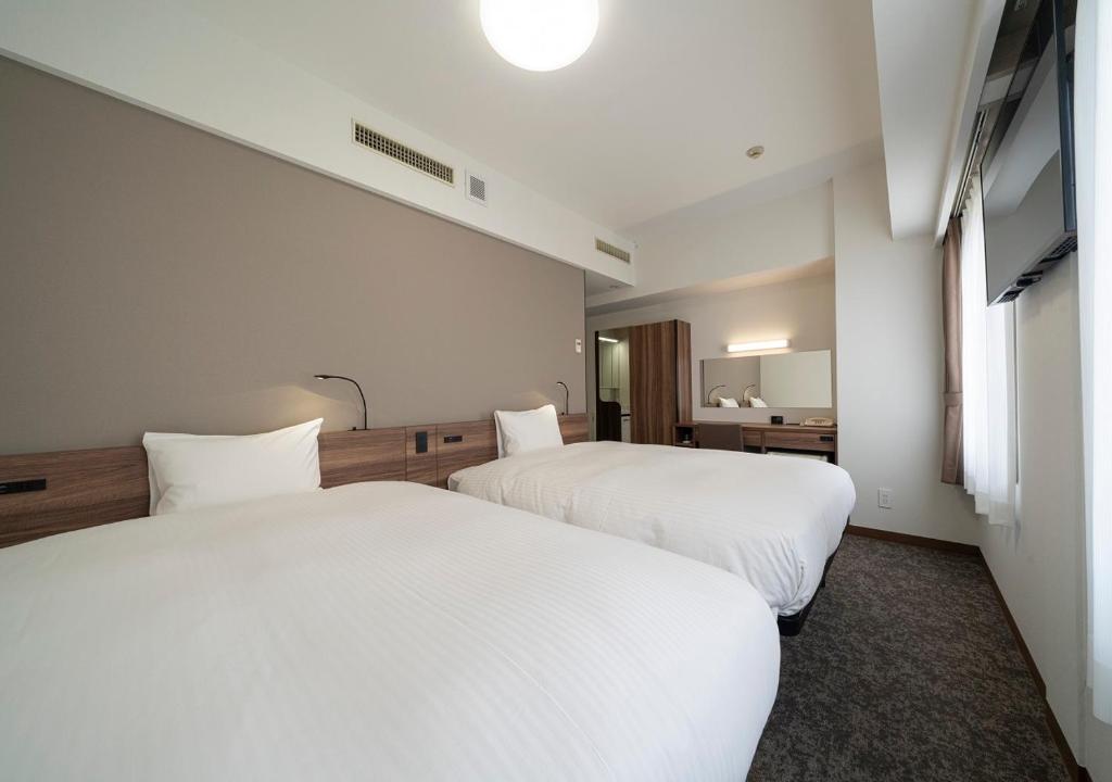 Postel nebo postele na pokoji v ubytování Nagoya B's Hotel