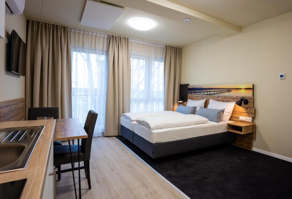una camera d'albergo con letto, tavolo e cucina di Gästehaus - Boardinghouse Magnetsried a Seeshaupt