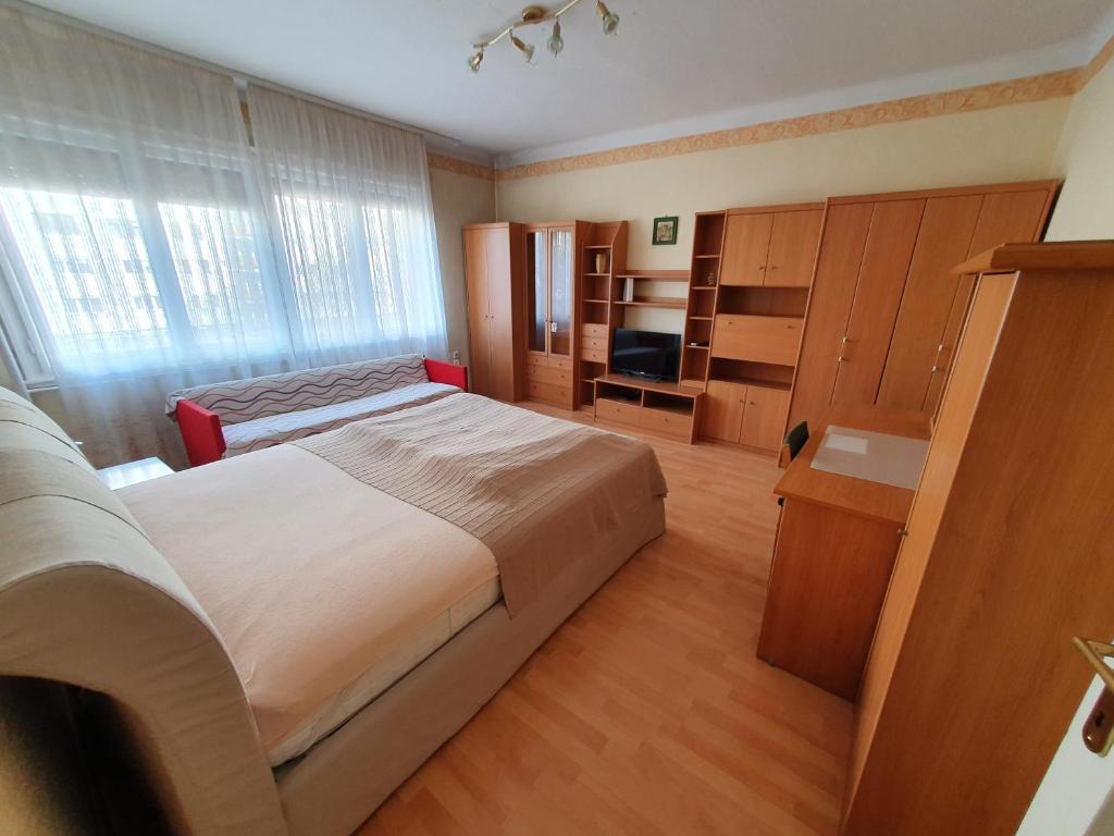 a bedroom with a large bed and a large window at M Apartments - Info Park in Budapest