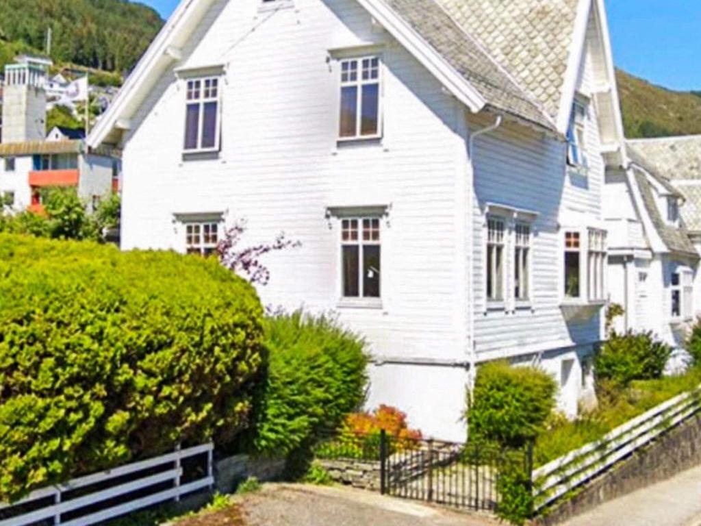 a white house with a fence in front of it at Holiday home MÅLØY in Måløy