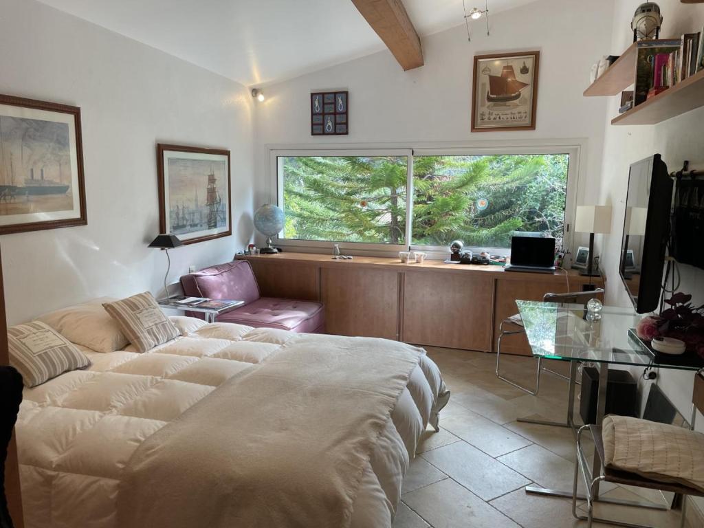 a living room with a large bed and a window at L'atelier du bonheur in Cassis