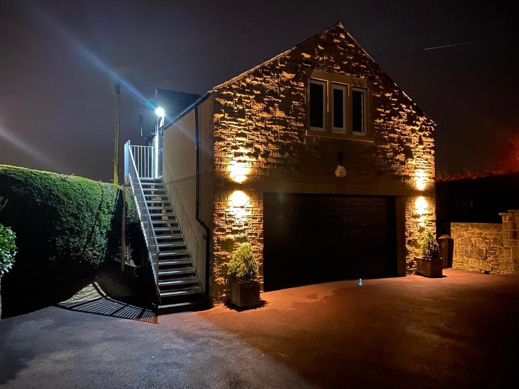 a brick building with a garage at night at Moll’n’Cliff in Silsden