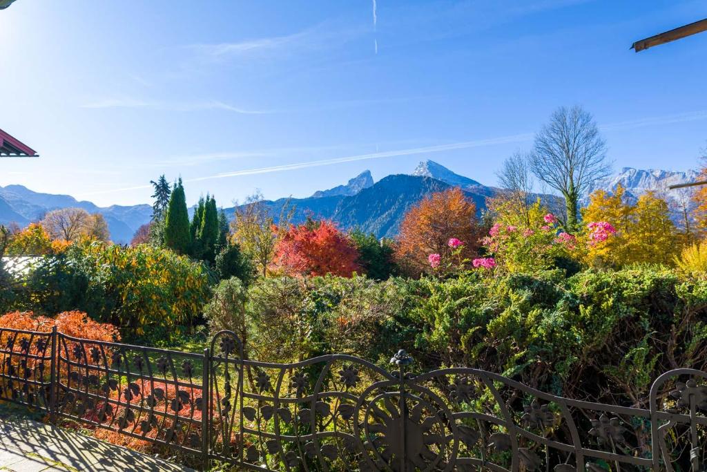 um jardim com folhagem de Outono e montanhas ao fundo em Ferienwohnungen Haus Sonnenwinkel em Oberschönau Eins