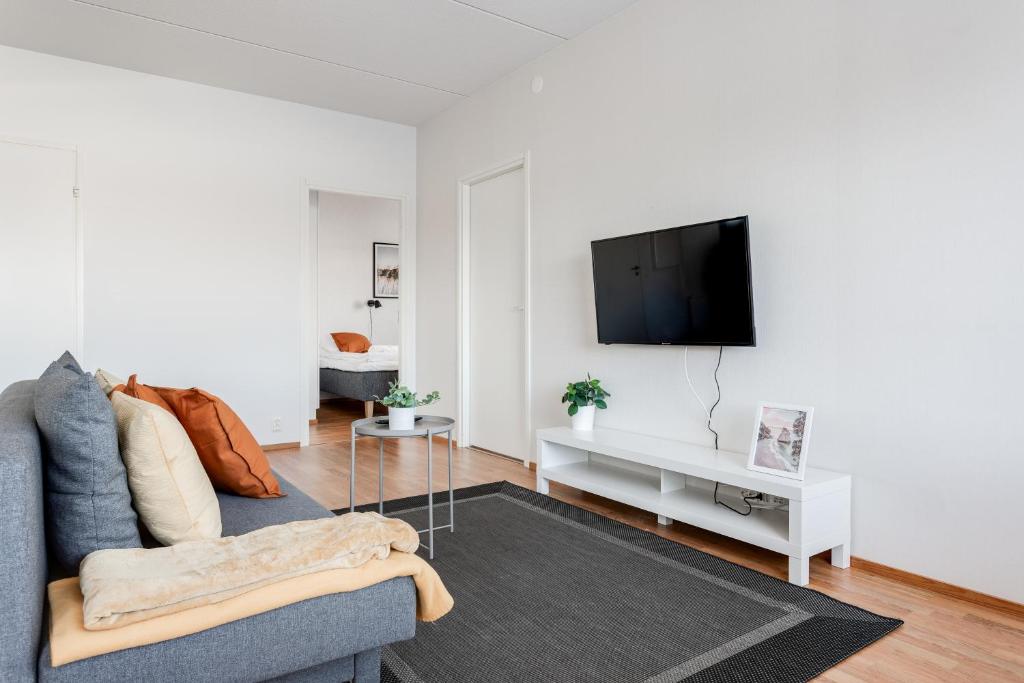 a living room with a couch and a flat screen tv at Hiisi Homes Tampere Muotiala in Tampere