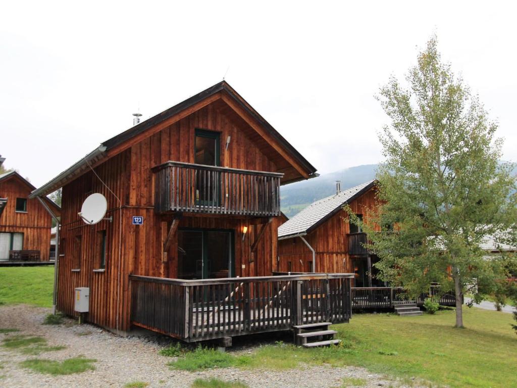 a wooden cabin with a balcony and a tree at Chalet in Stadl an der Mur Styria near ski area in Stadl an der Mur