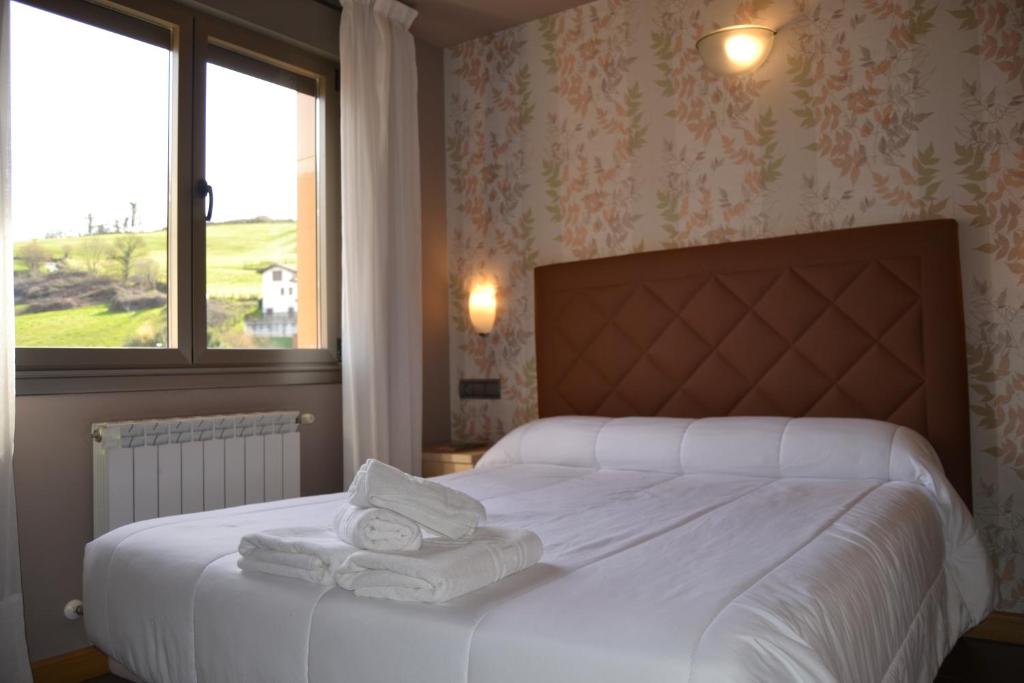 カンガス・デ・オニスにあるApartamentos Spa Cuetoのベッドルーム1室(白いベッド1台、タオル付)