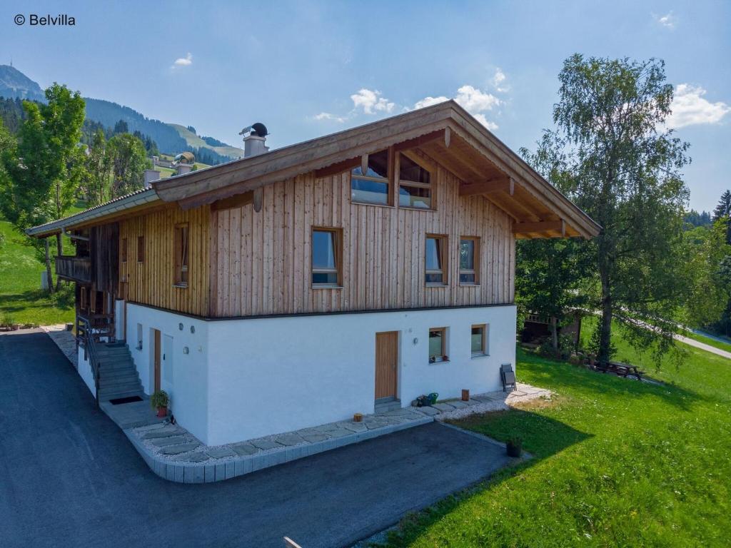 une petite maison avec un mur blanc dans l'établissement Flat directly on the ski slope with valley view, à St. Johann in Tirol