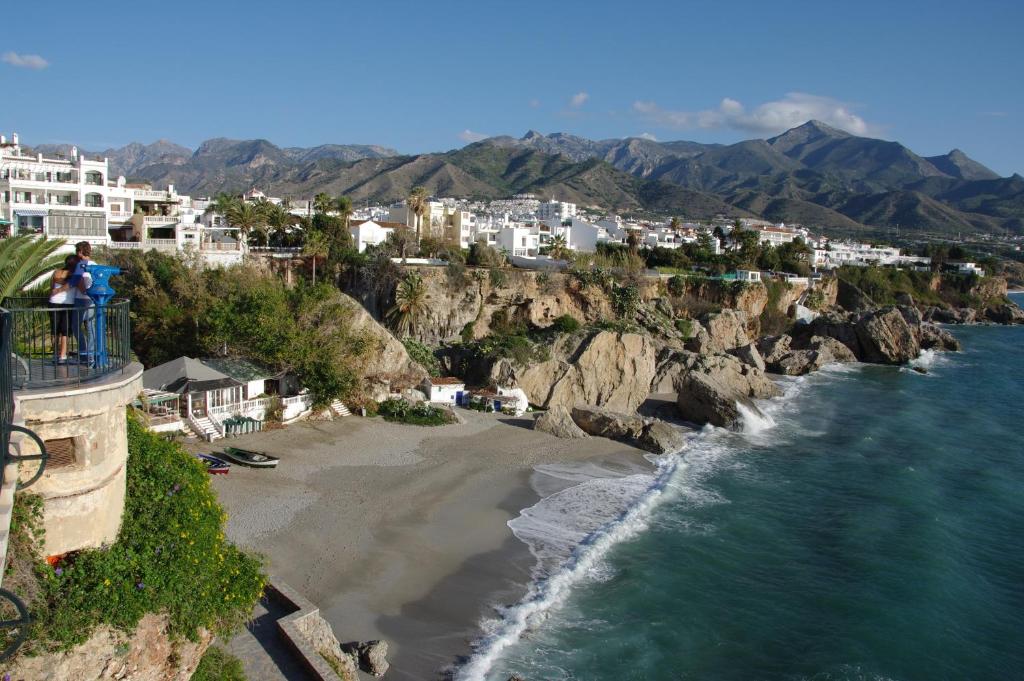 an aerial view of a beach with buildings and the ocean at Hostal Azahara in Nerja
