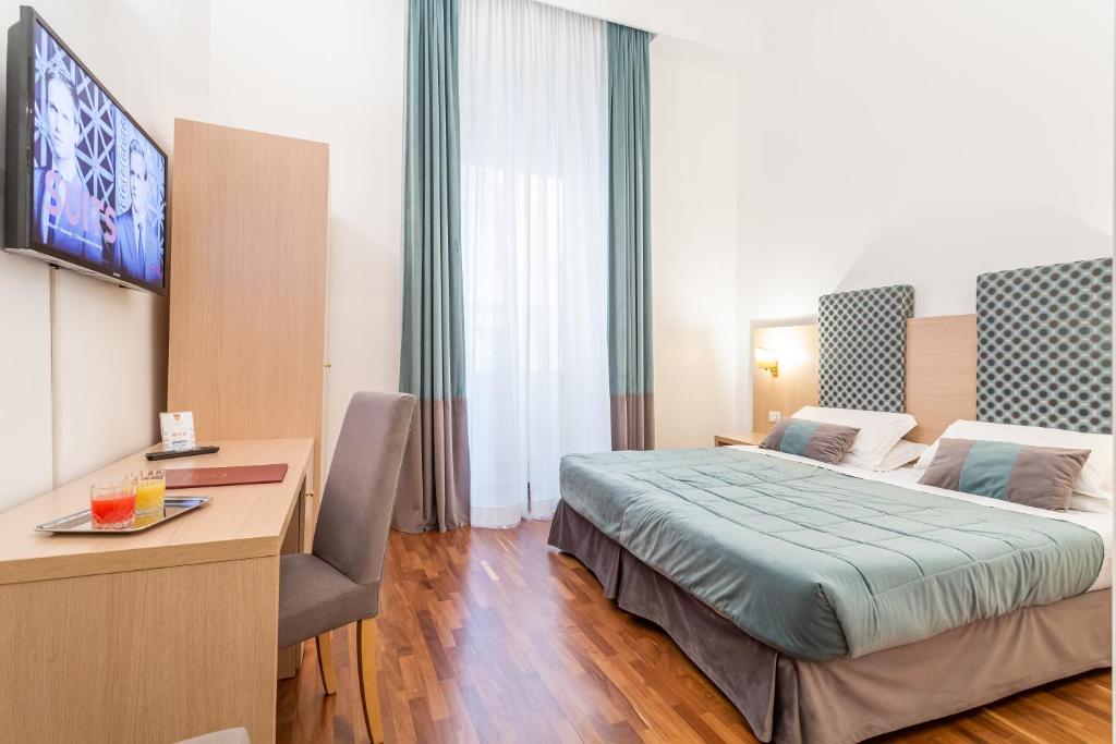 een hotelkamer met een bed en een bureau bij Hotel Medici in Rome