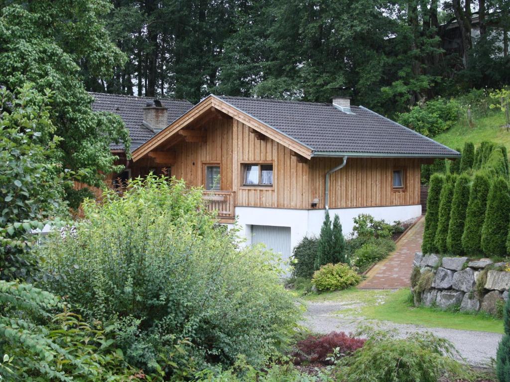 a wooden house with a garage in a garden at Simplistic Apartment in Piesendorf Walchen near Ski Slopes in Piesendorf