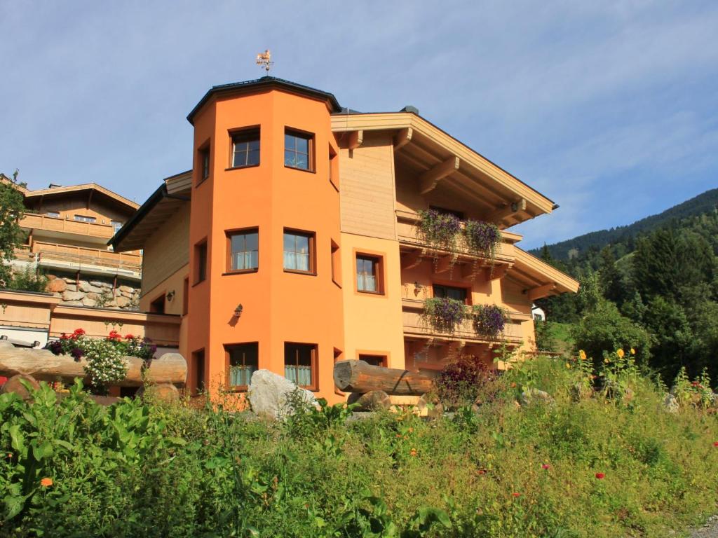 ザールバッハ・ヒンターグレムにあるModern Apartment in Saalbach Hinterglemm with Saunaの花の目の前のオレンジ色の建物