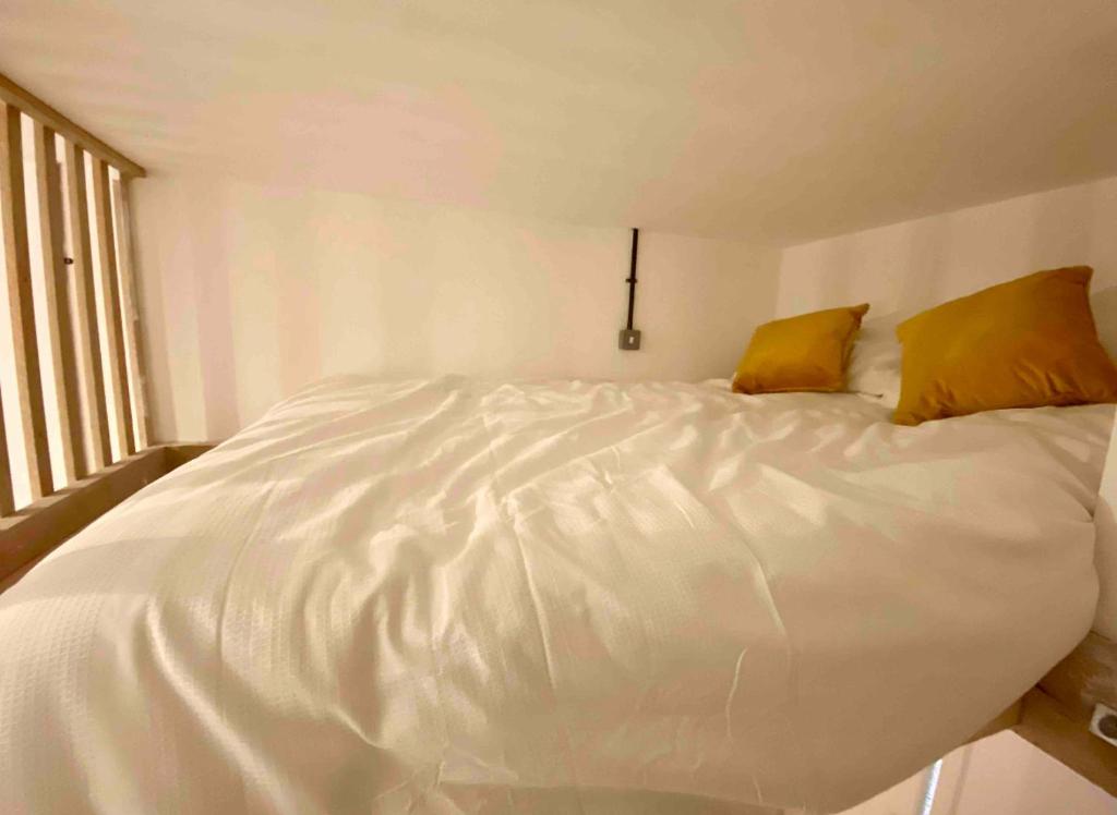 a large white bed with two yellow pillows on it at Flat 8, 10 St Johns in Bournemouth