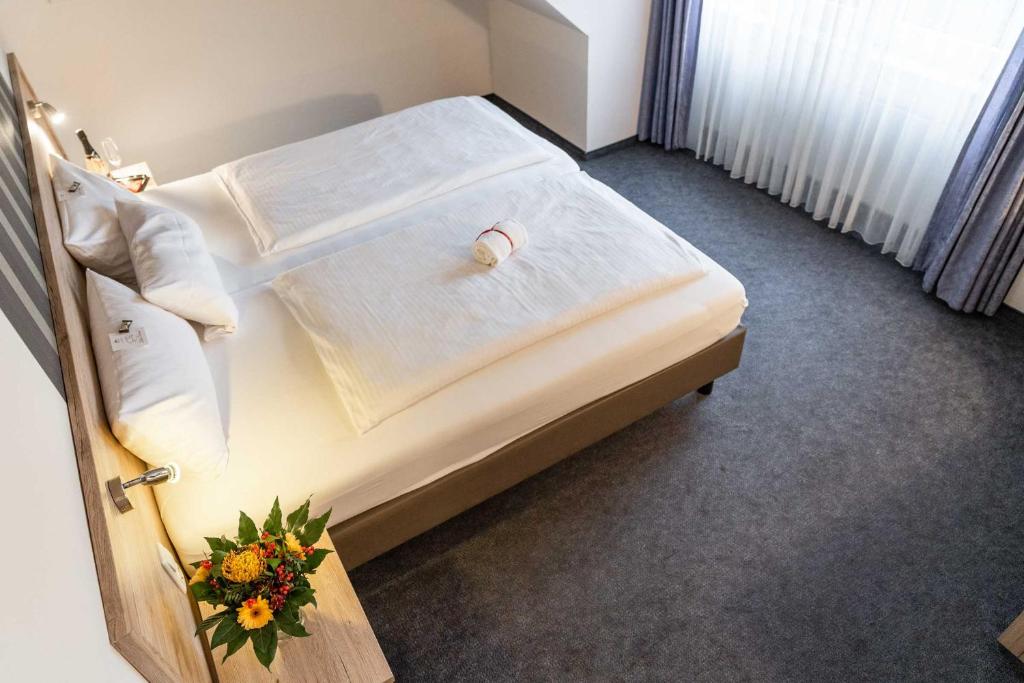 een slaapkamer met een bed met een bloemstuk erop bij Astoria Easy Hotel Essen in Essen