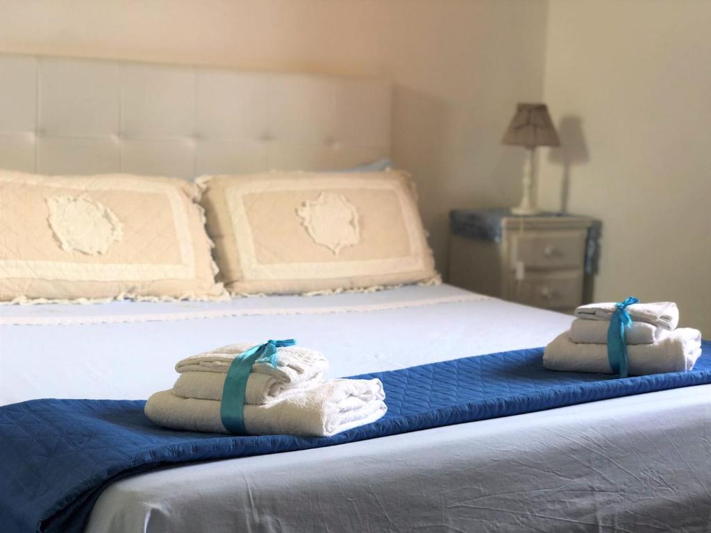 un letto con due asciugamani pieghevoli sopra di B&B Il Villino a Torre dell'Orso