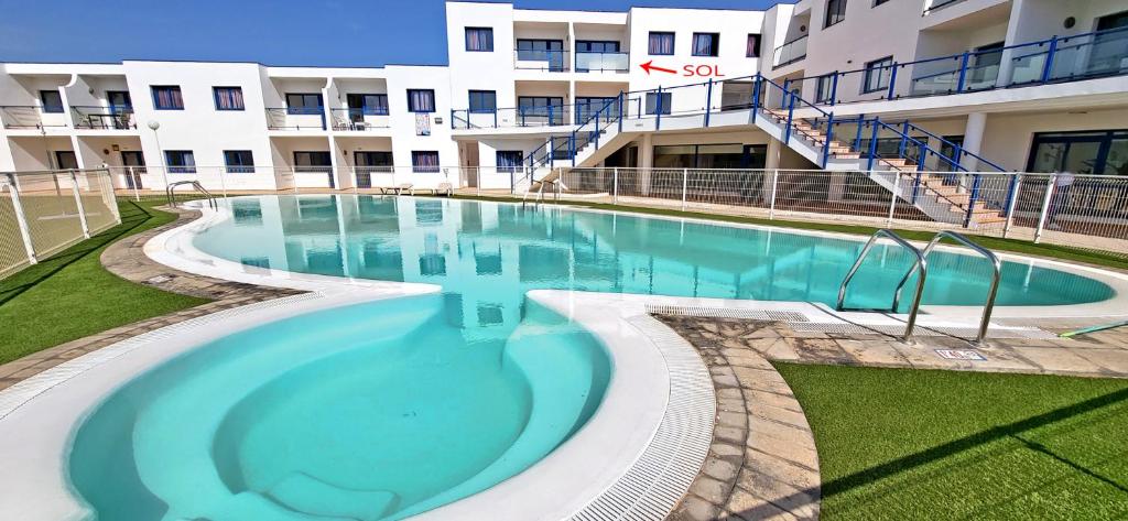 a large swimming pool in front of a building at Ferienwohnung SOL - Costa Calma - WiFi - Pool - max 4 Personen in Costa Calma