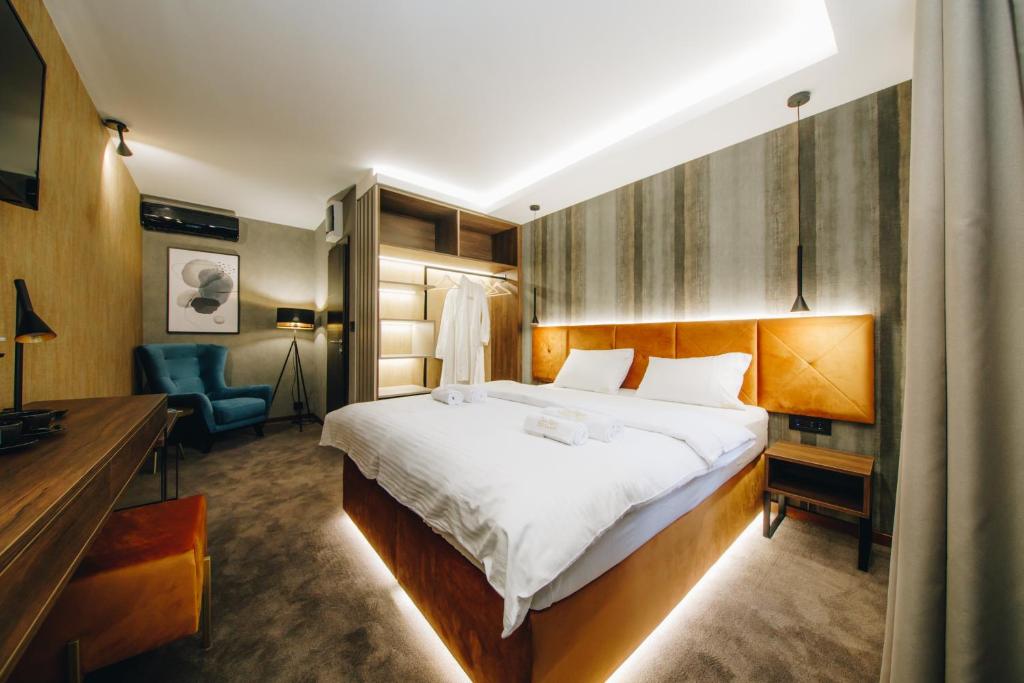 1 dormitorio con 1 cama grande y 1 silla azul en Boutique Luxury Apartments en Kragujevac