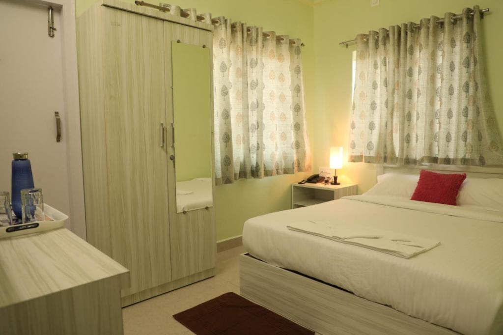 Postel nebo postele na pokoji v ubytování Sai Inn Mysore