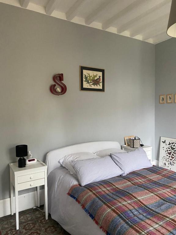 - une chambre blanche avec un lit et une table de nuit dans l'établissement Suite&Caux 1, à Cany-Barville