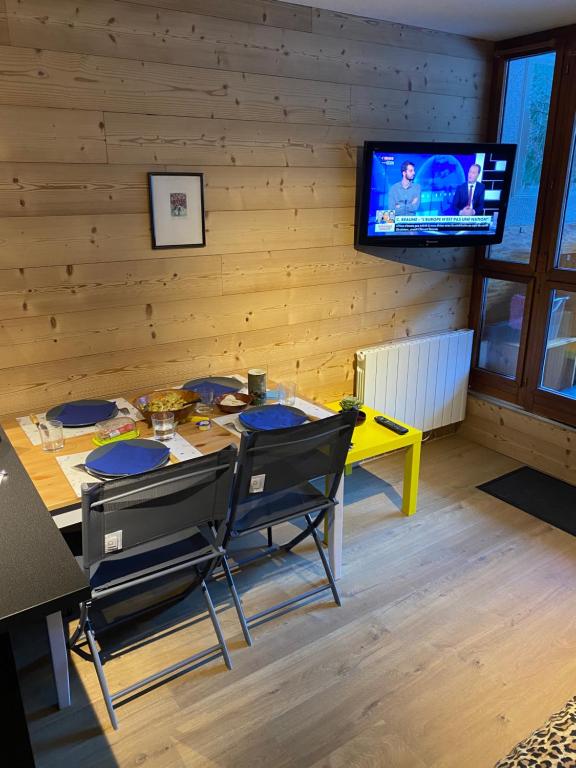 a dining room with a table and a tv at Studio Confortable style Chalet, Saint Lary Soulan centre village, 6 nuits minimum in Saint-Lary-Soulan