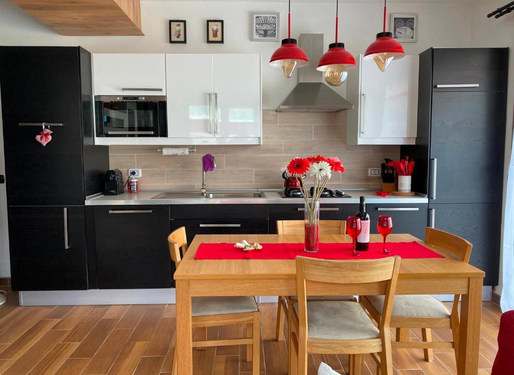 a kitchen with a wooden table with a red table cloth at Nidi del faggio rosso - Family Holiday Home in Maresca