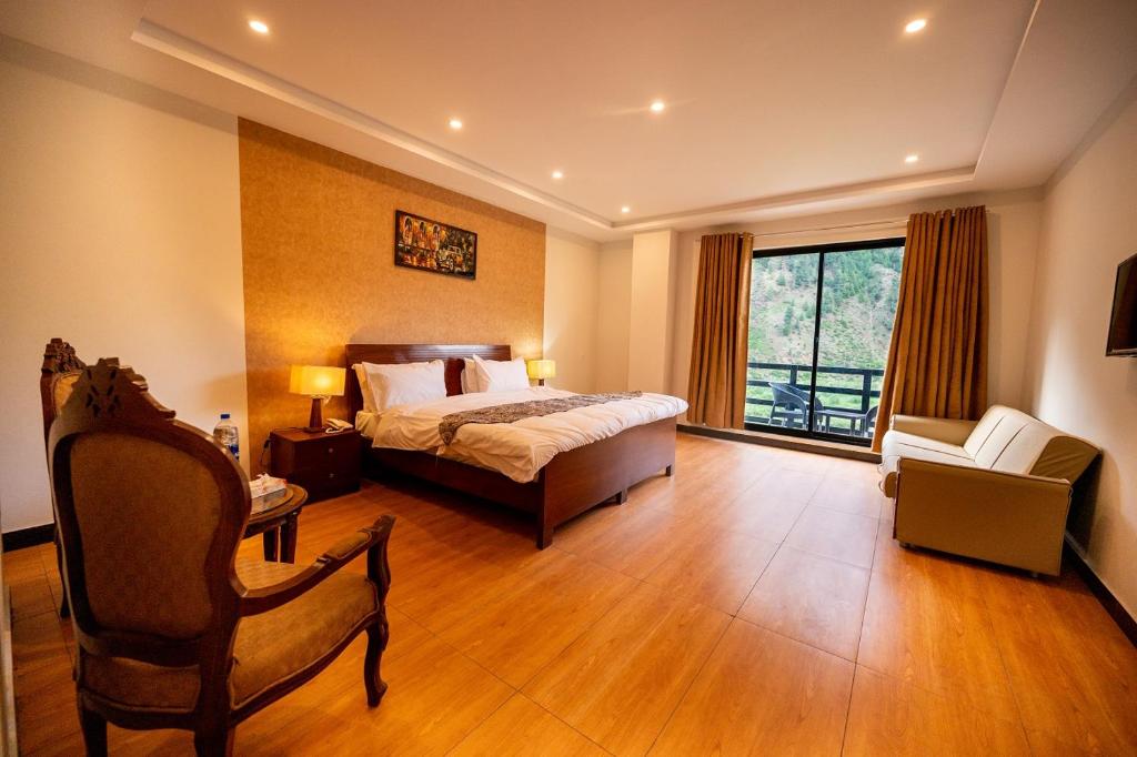 1 dormitorio con 1 cama, 1 silla y 1 ventana en Mount Feast Hotel en Naran