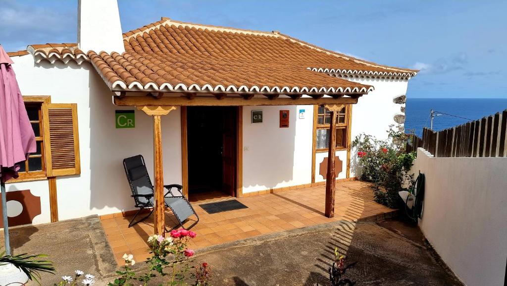 a small white house with a tile roof at Manos de Oro in Los Sauces