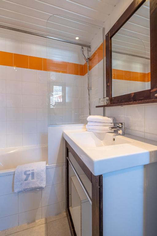 a bathroom with a sink and a bath tub at Résidence Pierre & Vacances Inter-Résidences in Tignes