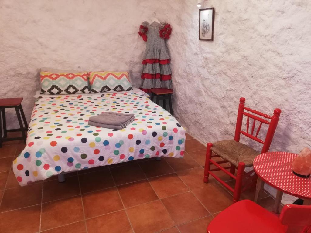 um quarto com uma cama, uma mesa e cadeiras em CUEVA EL DUENDE em Granada