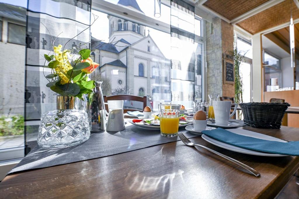 a wooden table with a vase of flowers on it at Hotel Rhönkitz in Bad Kissingen