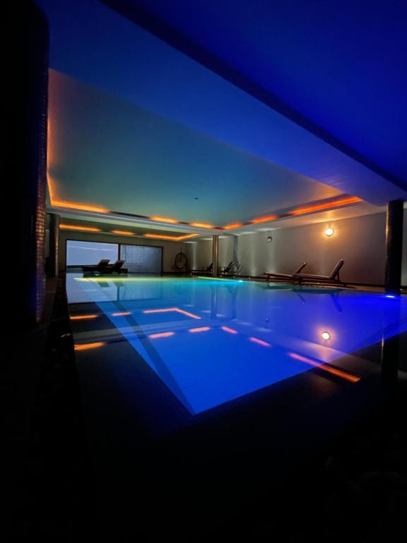 uma piscina iluminada à noite com luzes azuis em Fab View - Adults Only em Dingle