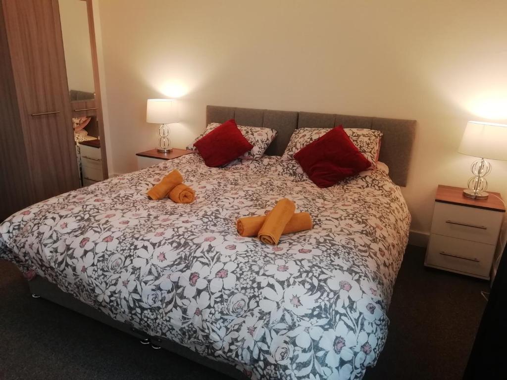 um quarto com uma cama com duas toalhas cor de laranja em Carvetii - Vincent House - Large 3 bedroom apartment with on-site parking em Fife