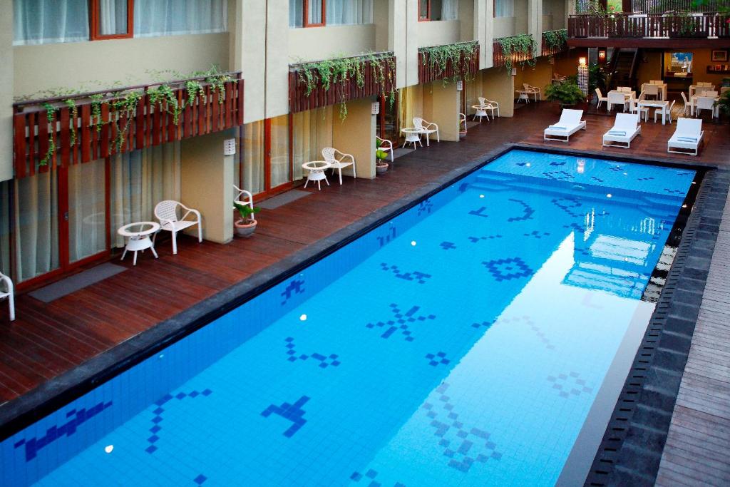 a large swimming pool in the middle of a hotel at Devata Suites and Residence in Legian