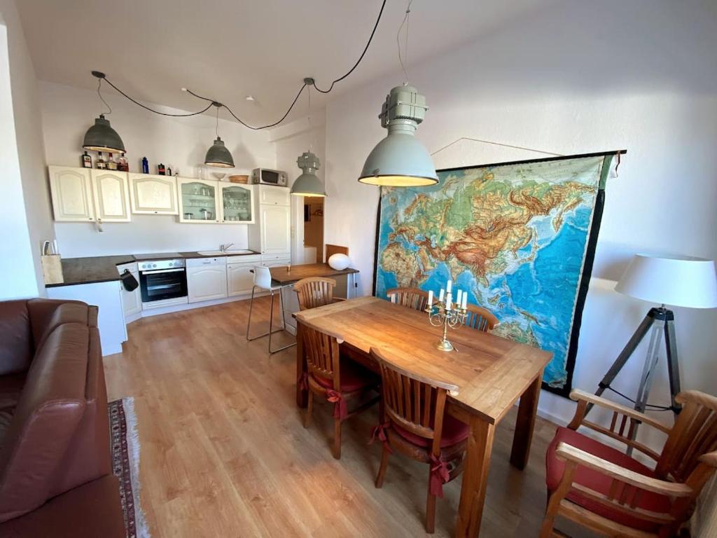 a living room with a table and a map on the wall at Helle 3-Zimmerwohnung in Uninähe in Braunschweig