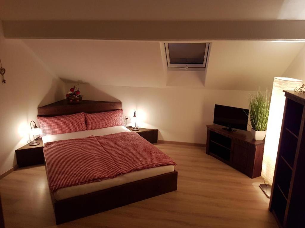 a bedroom with a bed and a flat screen tv at Ferienwohnung Weber Alpenglück in Lechbruck
