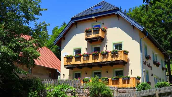 Una casa grande con un balcón con flores. en Ferienhaus Lotus Hof Stallegg, en Löffingen