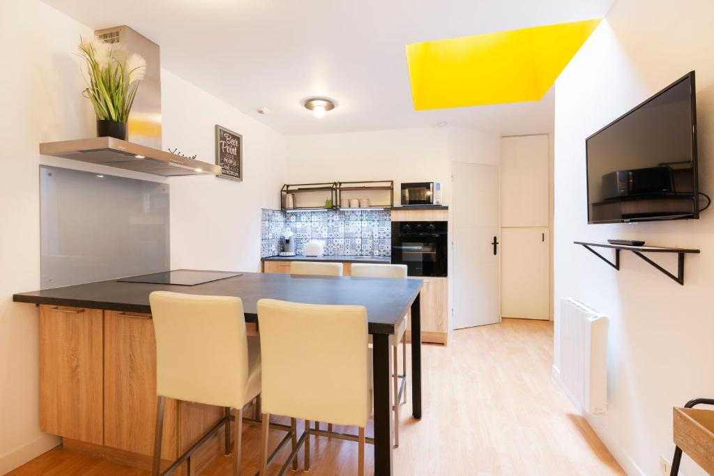 une cuisine avec une table et des chaises dans une pièce dans l'établissement Le carré de Nicolas, à Nancy