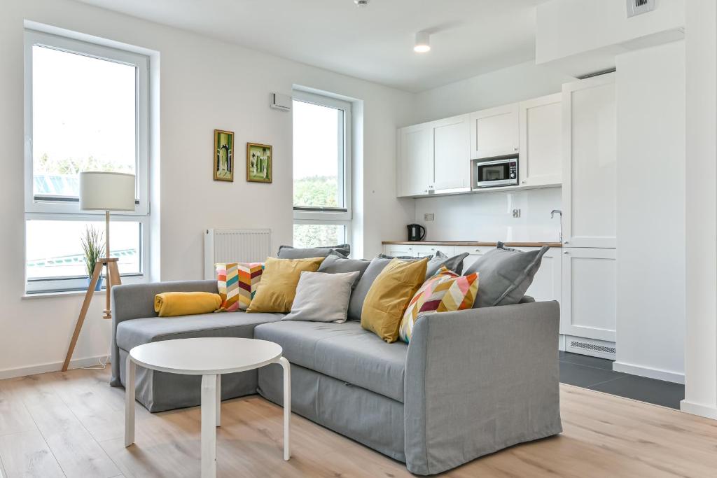 a living room with a gray couch and a table at LTC - Apartments Modern Tower in Gdynia