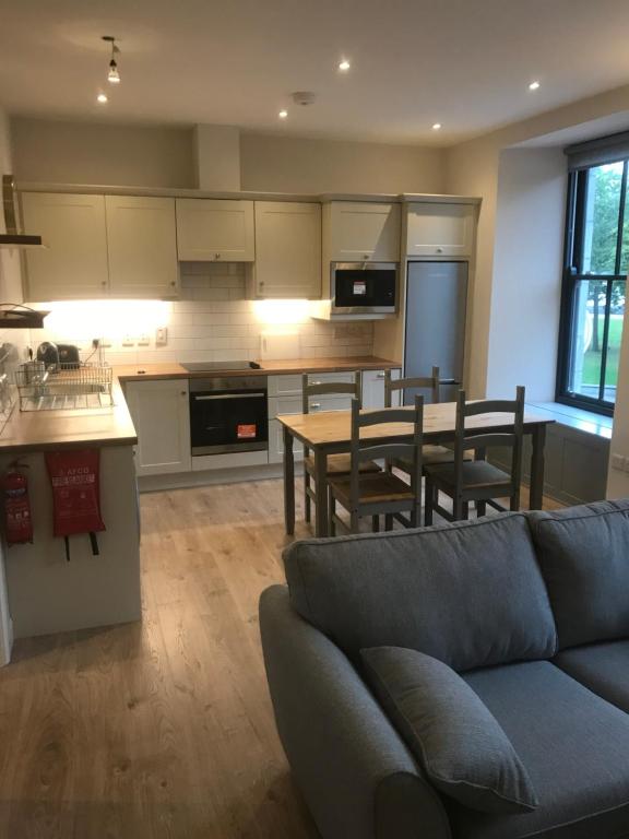 a living room with a couch and a kitchen at Eyre Luxury Apartment in Galway