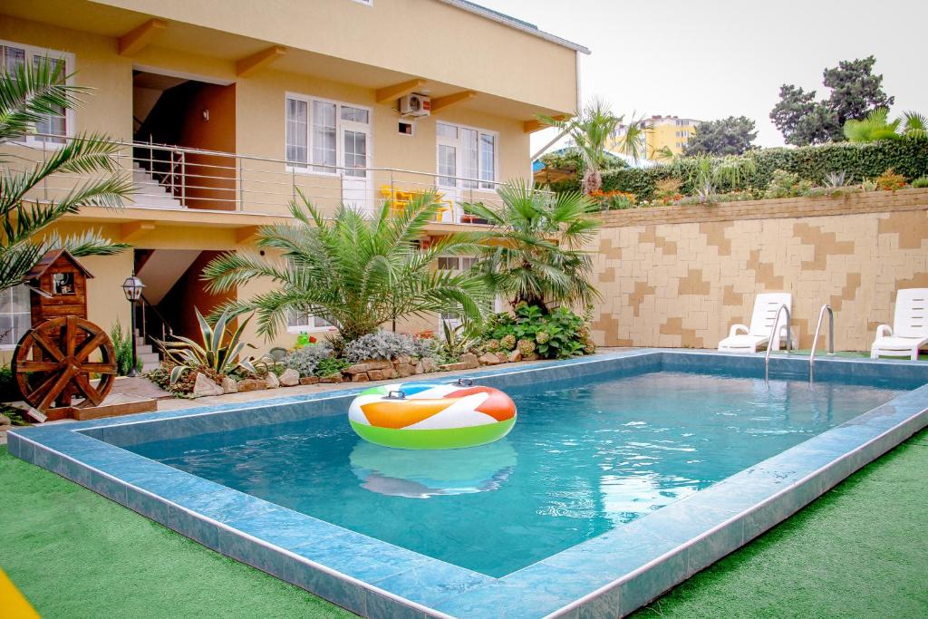 una piscina con una pelota de playa en una casa en Guest House Planet MOV, en Adler