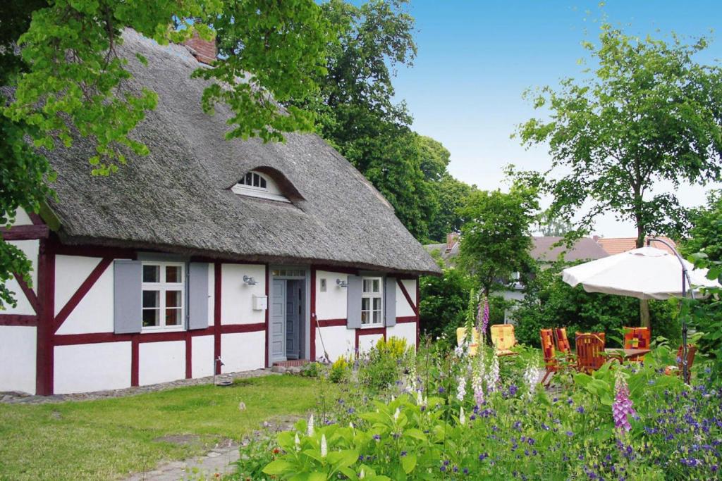 a cottage with a thatched roof in a garden at Apartment Dycke House, Zudar in Zudar