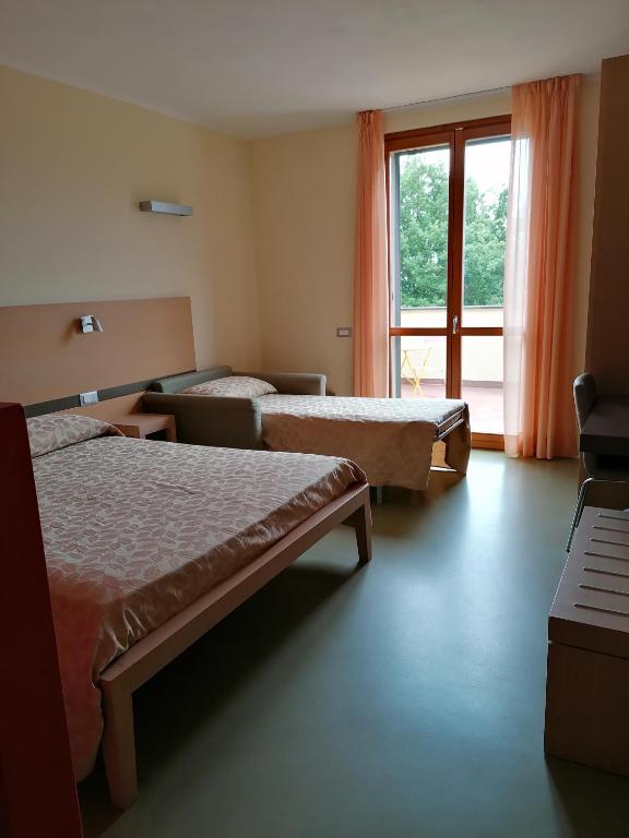 a hotel room with two beds and a window at Oroverde in Bergeggi